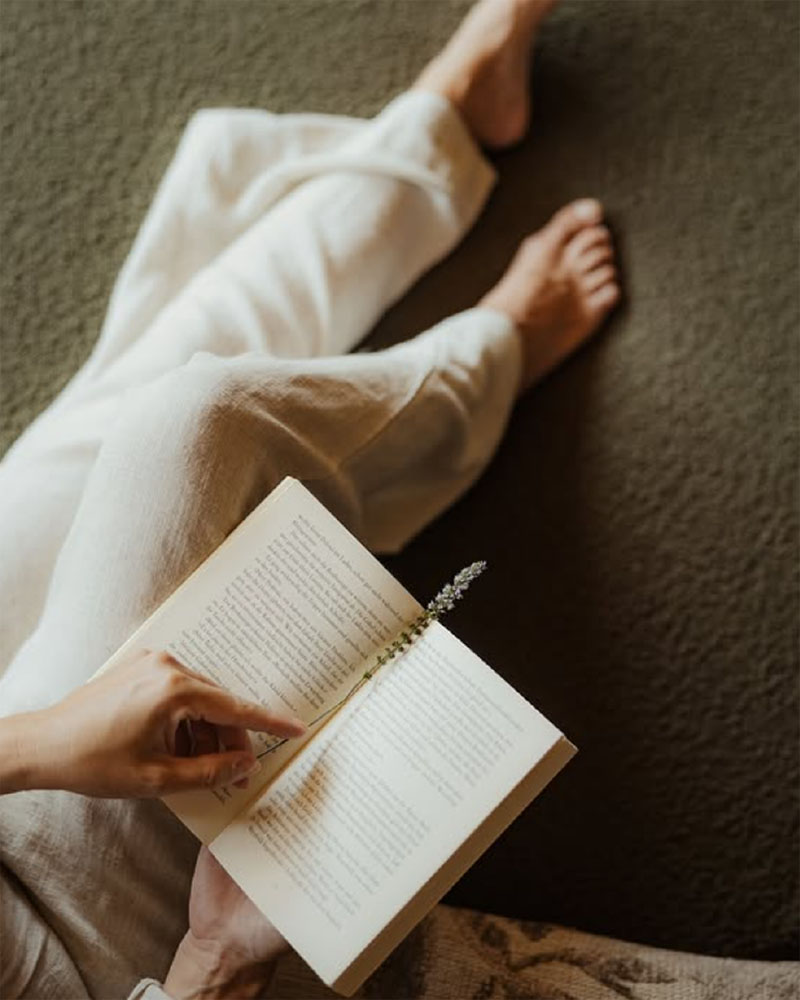 Eine Frau hockt auf dem Boden und hält ein Buch in der Hand